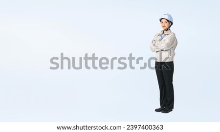 Standing Asian woman wearing work clothes. Engineer. Industrial worker. Wide angle visual for banners or advertisements. Royalty-Free Stock Photo #2397400363