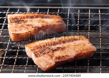 Thickly sliced ​​bacon on the grill Royalty-Free Stock Photo #2397404489