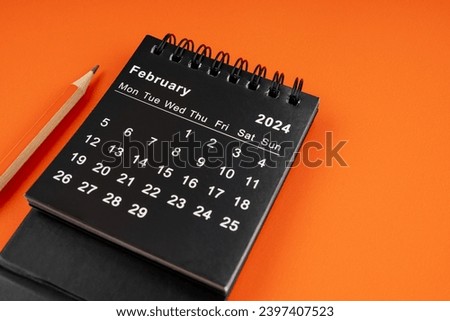 February 2024 desk calendar with pencil on orange color background. Royalty-Free Stock Photo #2397407523