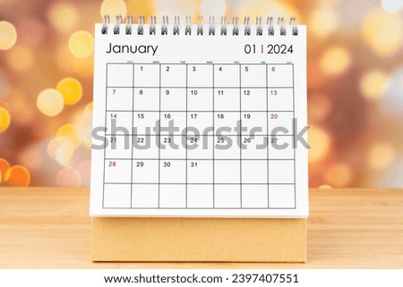 January 2024 desk calendar on wooden table with gold light bokeh background. New Year Concept. Royalty-Free Stock Photo #2397407551