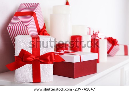 Christmas boxes and candles on mantelshelf, close-up