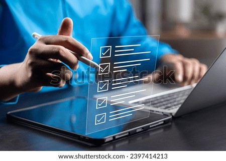Business performance monitoring and evaluation concept, Take an assessment, Business man using laptop and tablet online checklist survey, Filling out digital checklist, Questionnaire with checkboxes. Royalty-Free Stock Photo #2397414213