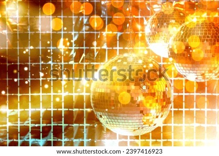 Shiny disco balls against foil party curtain under golden lights, space for text. Bokeh effect