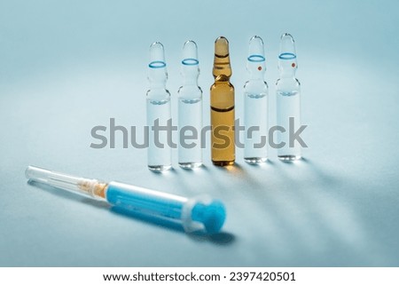 Syringe and needle with glass medical ampoule vials for injection. Medicine is dry white drug penicillin powder or liquid with of aqueous solution in ampulla Royalty-Free Stock Photo #2397420501