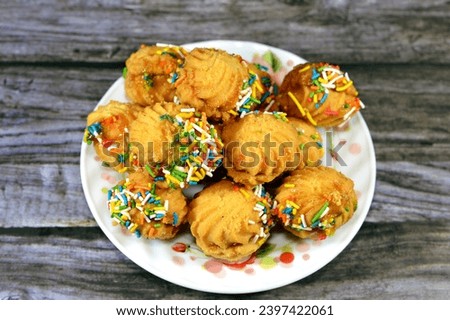 Traditional Arabic cookies for celebration of Islamic holidays of El-Fitr feast, petit four bakery (mignardises) stuffed with jam and nuts and covered with colorful sprinkle chocolate chips Royalty-Free Stock Photo #2397422061