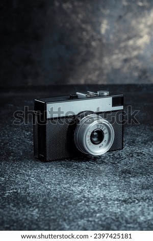 Old mechanical film camera. Long range hipster camera. Minimalist monolithic design of the camera and optics. Hobby of analog retro shooting on 35mm film. Royalty-Free Stock Photo #2397425181