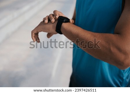 Close up picture of a mans arm with black watch