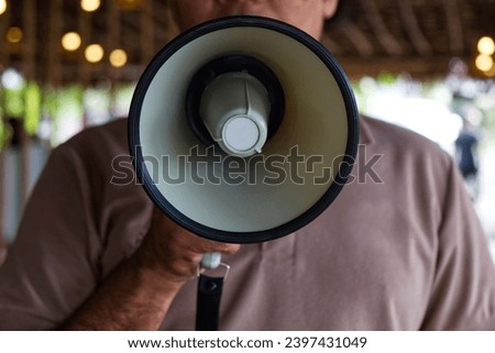 Man Using a Megaphone to Proclaim or Announcement Something with Very Loud Voice. Royalty-Free Stock Photo #2397431049