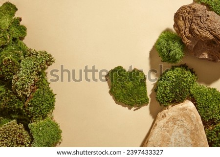 Abstract minimal scene for advertising with blocks of stone and patches of green moss decorated on beige background. Empty space to display cosmetic products. Top view, advertising photo