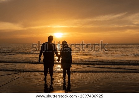 Young couple holding hands and looking ocean sunset enjoying  during travel holidays vacation getaway.