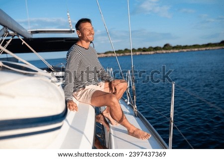 Man on a yacht smiling and feeling peaceful Royalty-Free Stock Photo #2397437369