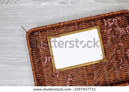 golden picture or photo frame mockup with pink baby's breath, gypsophila on esparto halfah background