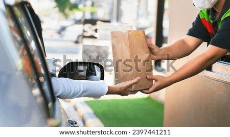 Woman getting fast food at drive-thru Royalty-Free Stock Photo #2397441211