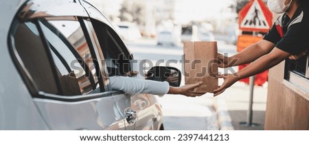 Woman getting fast food at drive-thru Royalty-Free Stock Photo #2397441213