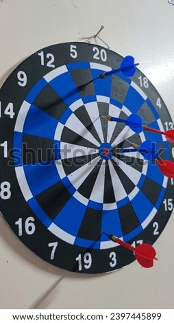 The large blue dart board were hanging on a wall and it is ready to play. 