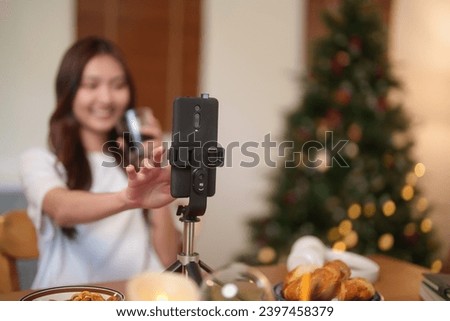 Young asian vj women using digital smartphone to recording video and speaking morning talks about news in live streaming on channel while drinking coffee and working with happiness at home studio.