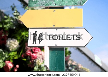wooden sign pointing to the ladies and gents toilets