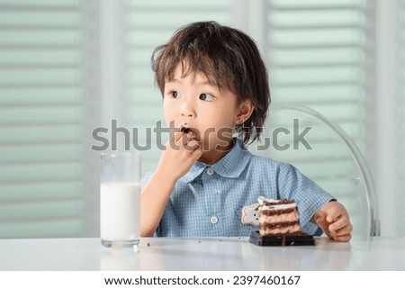 Lovely boy eating cake drink milk