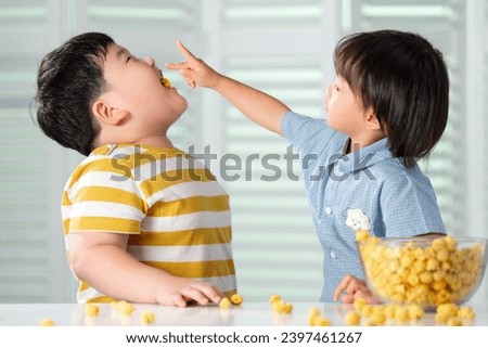 Two cute little boy eat popcorn