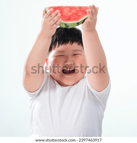 Lovely fat boy eating watermelon