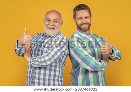photo of two generation family men wear checkered shirt, thumb up.