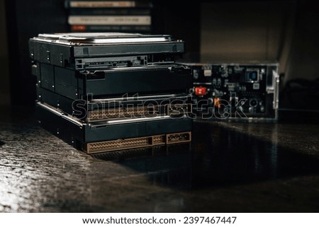 The stack of HDDs on the office table with case for HDD at the background
