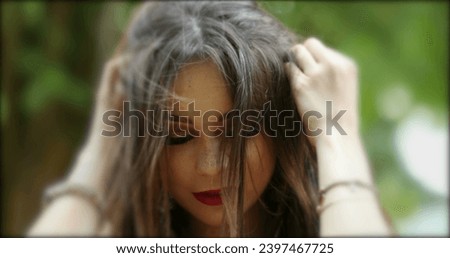 Pretty hispanic girl adjusting hair posing to camera. Young millennial woman in hero 20s in outdoor park