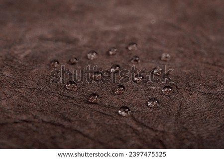 Round water drops on dark brown leather texture, side view, soft focus macro pattern Royalty-Free Stock Photo #2397475525