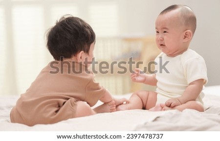 Two cute babies playing together