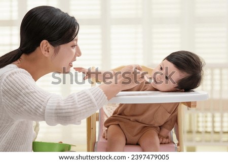 Young mothers feed their babies Royalty-Free Stock Photo #2397479005