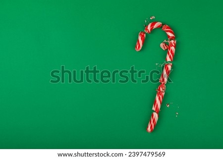 Candy cane.Christmas candy canes on a green background. Holiday greeting card. Concept for Christmas and New Year holidays. Winter. Flatlay, top view, copy space.
