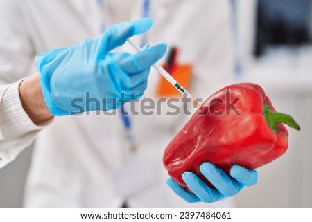 Young beautiful hispanic woman scientist injecting liquid on pepper at laboratory Royalty-Free Stock Photo #2397484061
