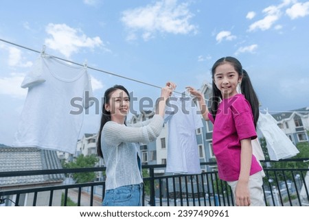 Hanging clothes young mothers and daughters