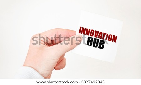 Businessman holding a card with text INNOVATION HUB, business concept