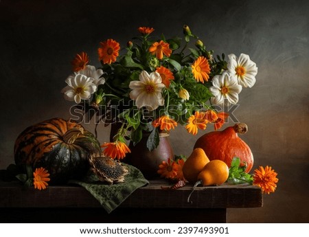 Still life with a bouquet of dahlias and calendulas and pumpkins on a dark background.