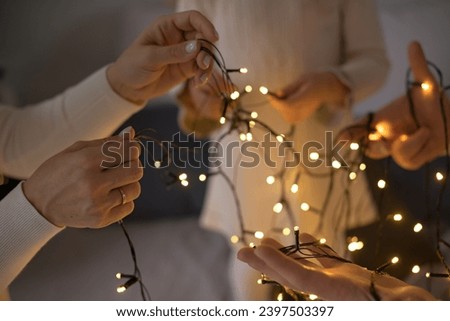 A family is unraveling a New Year's Christmas garland. Hands close up.