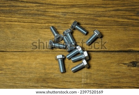 group of metal bolts on a wooden background. blur