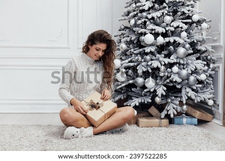 Woman decorating christmas tree gifts for new year