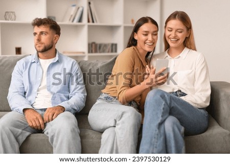 Relationship Vs Friendship. Woman Talking To Female Friend And Using Smartphone, Having Fun Ignoring Her Husband, While Man Sitting Bored Near Cheerful Girlfriends Indoor Royalty-Free Stock Photo #2397530129