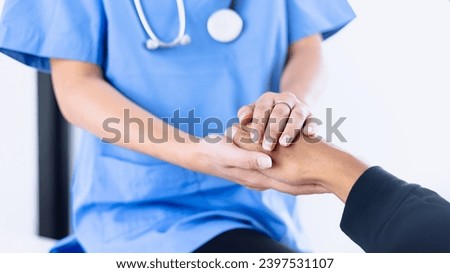 Female doctor holding hands a patient sitting at desk in hospital, Medicine and healthcare concept. Royalty-Free Stock Photo #2397531107
