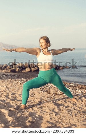 Warrior pose two on the beach young woman practice yoga Royalty-Free Stock Photo #2397534303