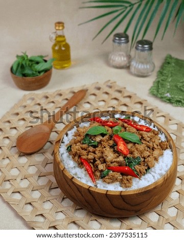 A Thai chicken basil rice bowl for lunch.  Use teak wood bowls and spoons.