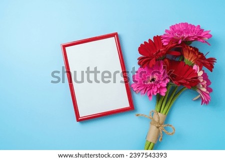Valentine's day picture frame mock up with flower bouquet on blue background. Top view, flat lay