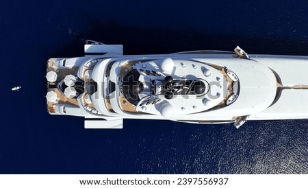 Aerial drone photo of latest technology modern mega yacht with wooden deck and helipad anchored in deep blue Aegean sea