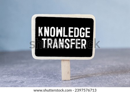knowledge transfer. text on white paper on wood background.