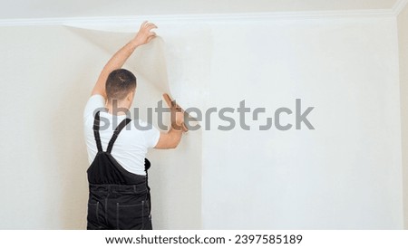 Worker pasting wallpapers. Professional glueing wallpapers. Royalty-Free Stock Photo #2397585189