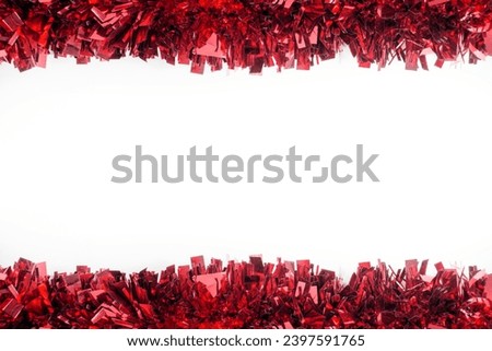 Red Christmas Tinsel close up as a border isolated against a white background, flay lay, top view.
