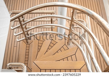 Detail shot of teak deck of modern white superyacht, with spotless stainless steel  Royalty-Free Stock Photo #2397605229