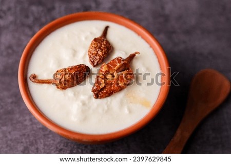 Bowl of homemade sour cream curd yogurt Dahi fresh herbs curry leaf Kerala India. Dairy product obtained coagulating milk process curdling. probiotic food tasty curd rice curry spices Royalty-Free Stock Photo #2397629845