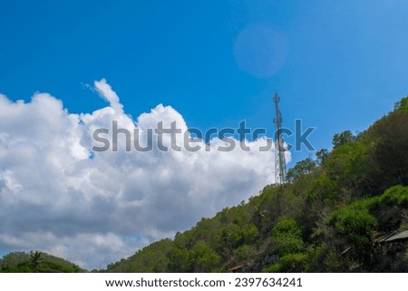 Aerial and spring view of Gunung Kidul hills with a blue sky and a high tower of internet lines